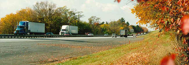 Trucks on PA Turnpike in fall foliage