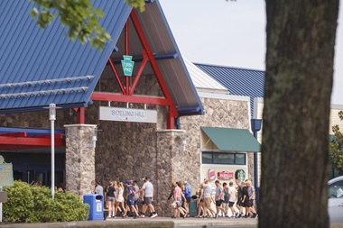 Large group walking into service plaza entrance