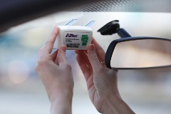 Customer mounting E-ZPass transponder onto windshield