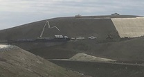 Seeding and placing erosion control mulch blanket on slopes